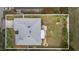 An aerial view shows a fenced-in yard with a fire pit, a playset and mature trees at 7120 Summit Dr, Winter Haven, FL 33884