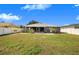Large backyard with green lawn and patio featuring outdoor seating, perfect for entertaining at 7120 Summit Dr, Winter Haven, FL 33884