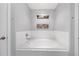 Bright bathroom featuring a large white soaking tub with tile surround and decor at 7120 Summit Dr, Winter Haven, FL 33884