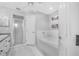 Bathroom with a bathtub, a separate shower, and a door to the outside at 7120 Summit Dr, Winter Haven, FL 33884