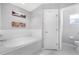 Bright bathroom featuring a large white soaking tub with tile surround and decor at 7120 Summit Dr, Winter Haven, FL 33884