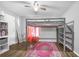 Bedroom showcasing a lofted bed frame with a pink rug and hardwood floors at 7120 Summit Dr, Winter Haven, FL 33884