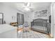 Bedroom featuring neutral paint, hardwood flooring, a ceiling fan, and a crib at 7120 Summit Dr, Winter Haven, FL 33884