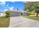 The driveway leading to a two-car garage gives plenty of space for parking, plus manicured landscaping at 7120 Summit Dr, Winter Haven, FL 33884