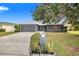 Charming single Gathering home features a well-manicured front yard with beautiful landscaping at 7120 Summit Dr, Winter Haven, FL 33884
