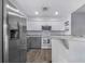 Modern kitchen with stainless steel refrigerator, white cabinets, and updated appliances at 7120 Summit Dr, Winter Haven, FL 33884