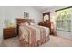 A well-lit bedroom featuring neutral carpet, a window and wood furniture at 799 Highland Crest Loop, Lake Wales, FL 33853
