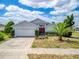 Charming single-story home featuring a two-car garage, manicured landscaping, and a red double-door entrance at 799 Highland Crest Loop, Lake Wales, FL 33853