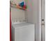 A clean and functional laundry area with a washing machine and storage shelves at 799 Highland Crest Loop, Lake Wales, FL 33853