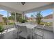 A covered patio with a white dining set and a screened view of the garden at 799 Highland Crest Loop, Lake Wales, FL 33853