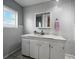 Bathroom with a white vanity, a large mirror, and a bright window at 803 7Th Ne St, Fort Meade, FL 33841