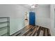 Spare bedroom with modern wood flooring, ceiling fan, and a blue interior door at 803 7Th Ne St, Fort Meade, FL 33841