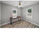 Cozy bedroom featuring wood floors, a ceiling fan, and natural light from two windows at 803 7Th Ne St, Fort Meade, FL 33841