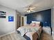Comfortable bedroom featuring wood floors, a ceiling fan, and a blue accent wall at 803 7Th Ne St, Fort Meade, FL 33841
