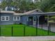 Charming home exterior with a metal roof, fenced artificial grass yard, and a covered carport at 803 7Th Ne St, Fort Meade, FL 33841