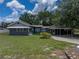 Charming single-story home with a lush green lawn and a covered parking area at 803 7Th Ne St, Fort Meade, FL 33841