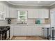 Well-lit kitchen features white cabinetry, stainless steel appliances and a view from the window at 803 7Th Ne St, Fort Meade, FL 33841