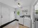 Laundry room featuring tile floors, modern washer/dryer, and access to the backyard at 803 7Th Ne St, Fort Meade, FL 33841