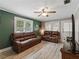 Cozy living room featuring two leather sofas, fresh paint, modern flooring, and ample natural light at 803 7Th Ne St, Fort Meade, FL 33841