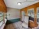 Comfortable sunroom featuring wood paneling, ample windows, and stylish seating for relaxation at 803 7Th Ne St, Fort Meade, FL 33841