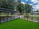 Exterior shot of an artificial grass yard, fenced in for safety and privacy, and covered parking at 803 7Th Ne St, Fort Meade, FL 33841