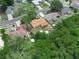 Aerial view of a residential area with tree coverage, highlighting a single-Gathering home with a brown roof and a storage shed at 808 Ware Ne Ave, Winter Haven, FL 33881