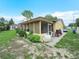 This exterior shot showcases a screened-in porch and backyard, complete with lush greenery and a concrete patio at 808 Ware Ne Ave, Winter Haven, FL 33881