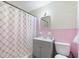Pink and white bathroom with geometric shower curtain, sink, and toilet at 825 Augusta St, Lakeland, FL 33805