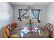 Bright dining area featuring a glass-top table set for four, illuminated by natural light from the window at 825 Augusta St, Lakeland, FL 33805