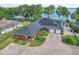 Stunning aerial view of the brick home showcasing well-manicured landscaping, solar panels, and a spacious driveway at 9950 W Lake Marion Rd, Haines City, FL 33844