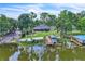 Aerial view of a waterfront property with boat docks and a screened lanai, nestled among mature trees at 9950 W Lake Marion Rd, Haines City, FL 33844