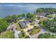 Beautiful aerial view of lakefront property featuring a well-maintained lawn, solar panels and mature landscaping at 9950 W Lake Marion Rd, Haines City, FL 33844