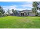 Expansive backyard featuring a screened-in lanai, lush green lawn, and mature trees, ideal for outdoor living at 9950 W Lake Marion Rd, Haines City, FL 33844