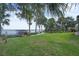 Expansive green backyard leading to the lake with mature trees and a dock at 9950 W Lake Marion Rd, Haines City, FL 33844