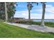 Backyard features waterfront views with mature trees, green grass and sandy beach at 9950 W Lake Marion Rd, Haines City, FL 33844