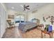 Cozy bedroom with a large window, ceiling fan, rocking chair, and neutral tile flooring at 9950 W Lake Marion Rd, Haines City, FL 33844