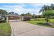 View of brick-paved driveway leading to a gated home, surrounded by lush landscaping at 9950 W Lake Marion Rd, Haines City, FL 33844