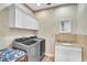 Laundry room featuring a washer, dryer, sink, and countertop with cabinets at 9950 W Lake Marion Rd, Haines City, FL 33844