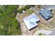 Aerial view of the house featuring its metal roof and surrounded by lush vegetation and a neighboring blue home at 101 Babson Heights Dr, Babson Park, FL 33827