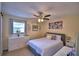 Well-lit bedroom featuring a ceiling fan, modern dresser, and decorative floral artwork at 101 Babson Heights Dr, Babson Park, FL 33827