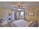 Bedroom with neutral walls, ceiling fan, white bedding, and decorative accents, and access to the bathroom at 101 Babson Heights Dr, Babson Park, FL 33827