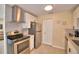 Bright kitchen featuring stainless steel appliances, white cabinetry, granite counters and tiled backsplash and flooring at 101 Babson Heights Dr, Babson Park, FL 33827