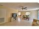 Open floor plan living room and dining area with tile flooring, ceiling fan, dining table, and TV console at 101 Babson Heights Dr, Babson Park, FL 33827