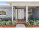 Charming front door with decorative accents and a mosaic tiled porch, surrounded by lush landscaping at 1010 Biltmore Nw Dr, Winter Haven, FL 33881