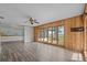 Open concept living room featuring wood paneling, ceiling fan, and scenic lake views at 1010 Biltmore Nw Dr, Winter Haven, FL 33881