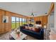Bright living room featuring wood paneling, lake views, and stylish blue modern furniture at 1010 Biltmore Nw Dr, Winter Haven, FL 33881