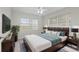 Bright bedroom with an inviting bed, decorative lamps, and large windows for natural light and water views at 1010 Biltmore Nw Dr, Winter Haven, FL 33881