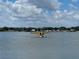 Small yellow aircraft sitting on tranquil water with a backdrop of a clear sky and greenery at 1010 Biltmore Nw Dr, Winter Haven, FL 33881