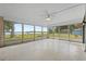 Bright sunroom with a fan overhead and gorgeous lake views through the many surrounding windows at 1010 Biltmore Nw Dr, Winter Haven, FL 33881