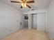 This carpeted bedroom features a ceiling fan, closet, and adjoining bathroom at 1055 Sunshine Sw Way, Winter Haven, FL 33880